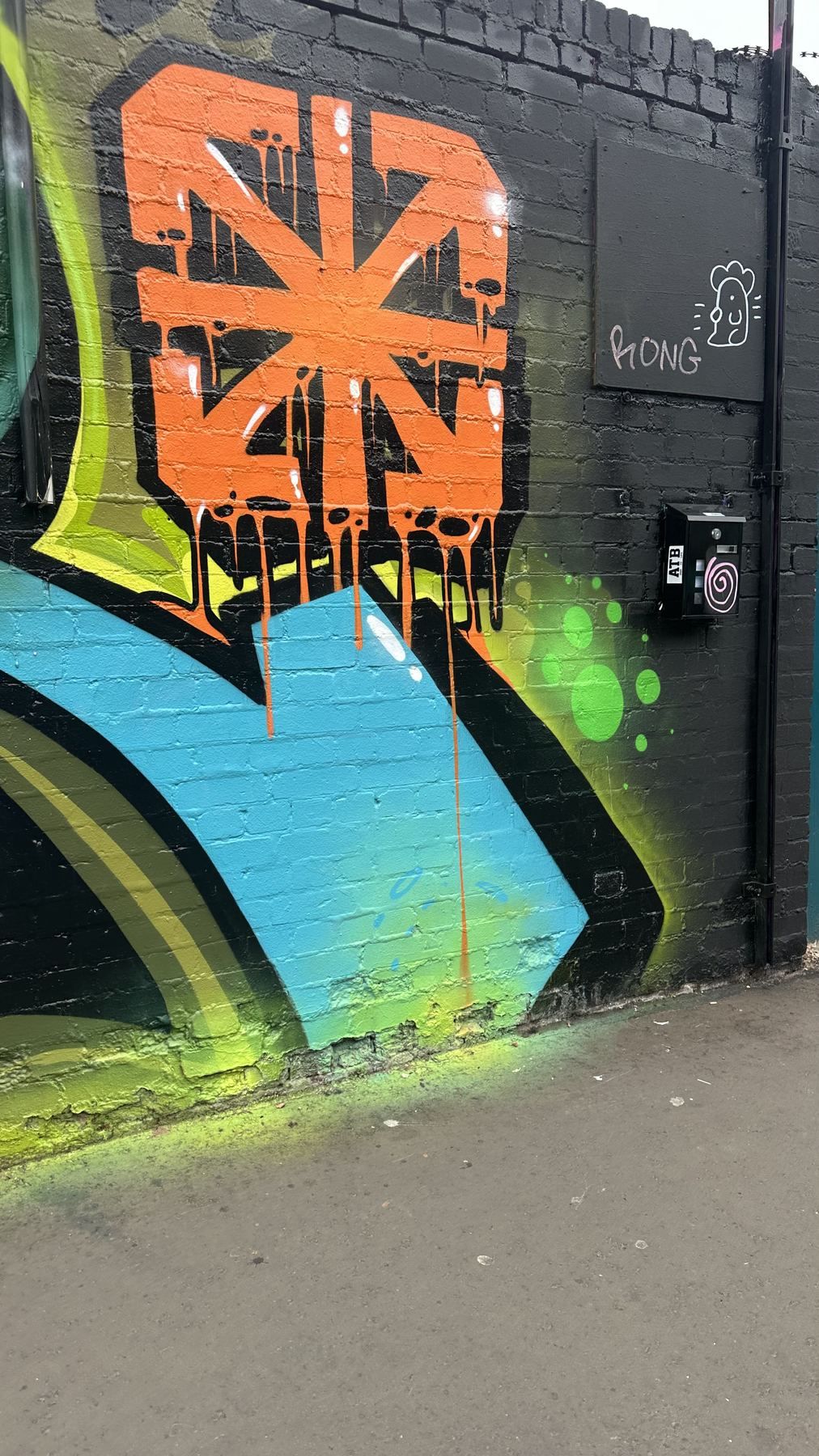 A large orange painted mural on a brick wall near the factory