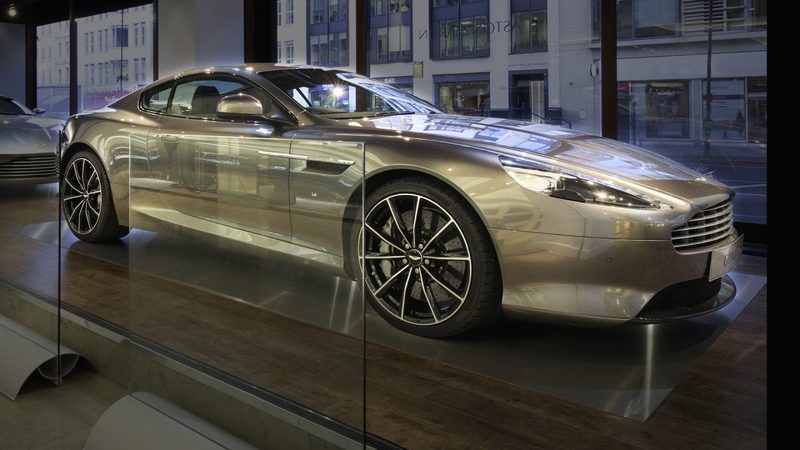 A silver sports car on a plinth in a shop window