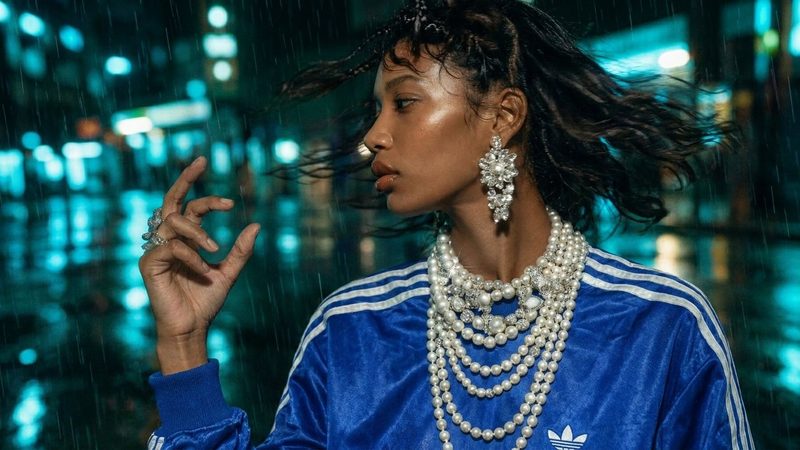 A woman in a blue jacket and pearl necklaces turning her head on a rainy street